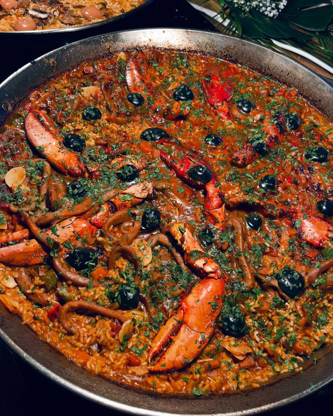 Arroz con bogavante y aceitunas negras en paella