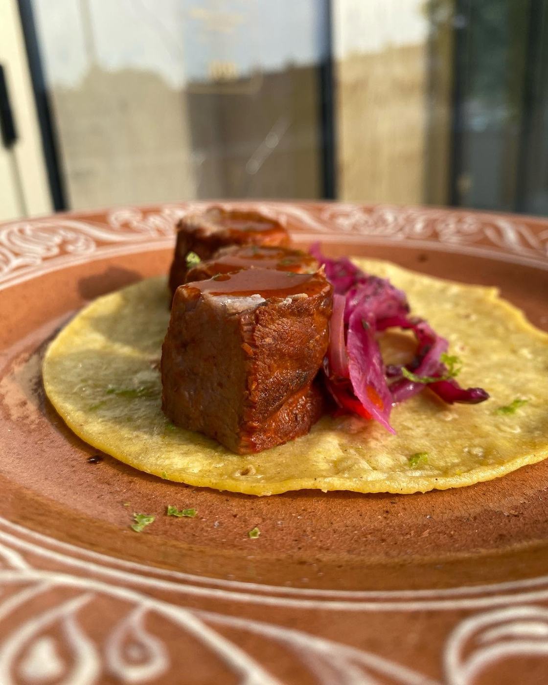 Panceta sobre tortilla de maíz con cebolla encurtida