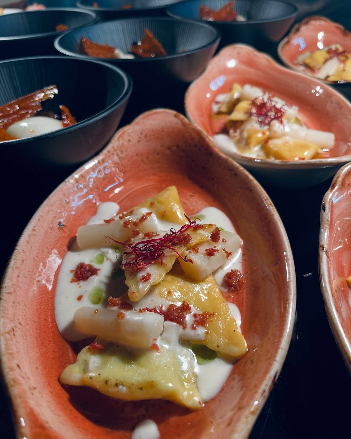 Raviolis con salsa cremosa en fuente de barro
